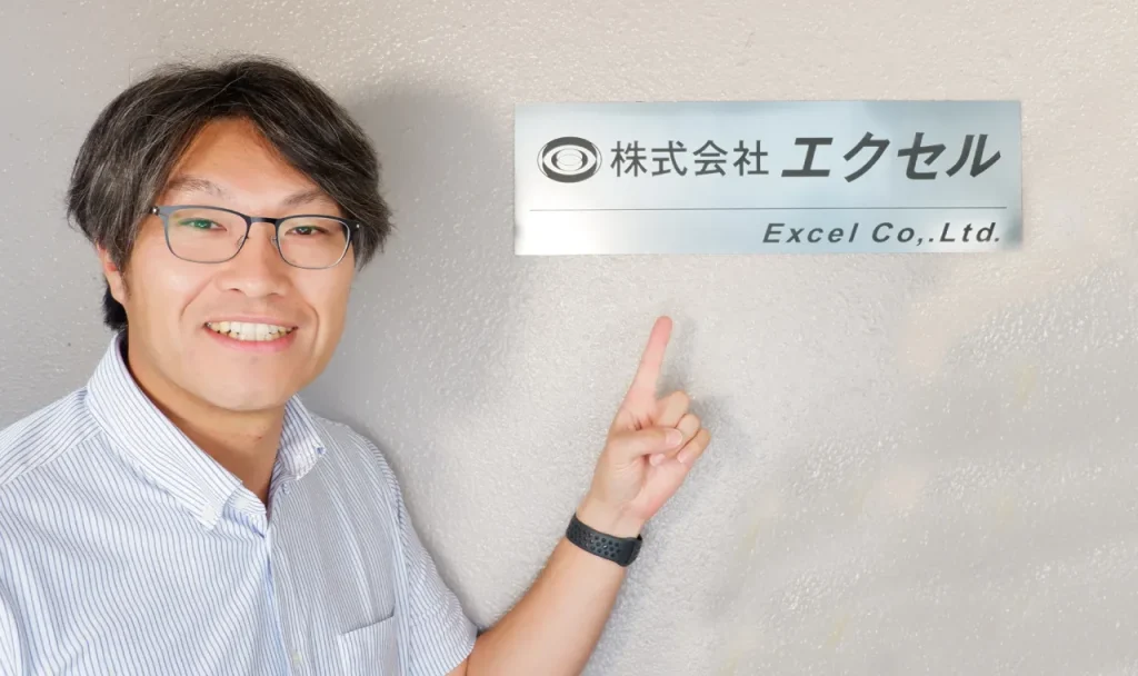 「株式会社エクセル」看板と伊藤たかやす社長